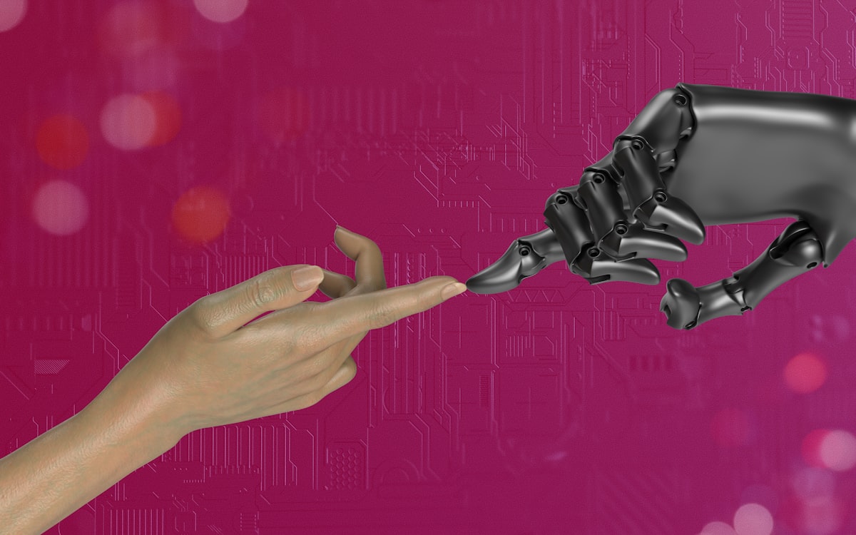 Mão humana tocando a mão de um robô — a diferença entre um chatbot e um agente de IA