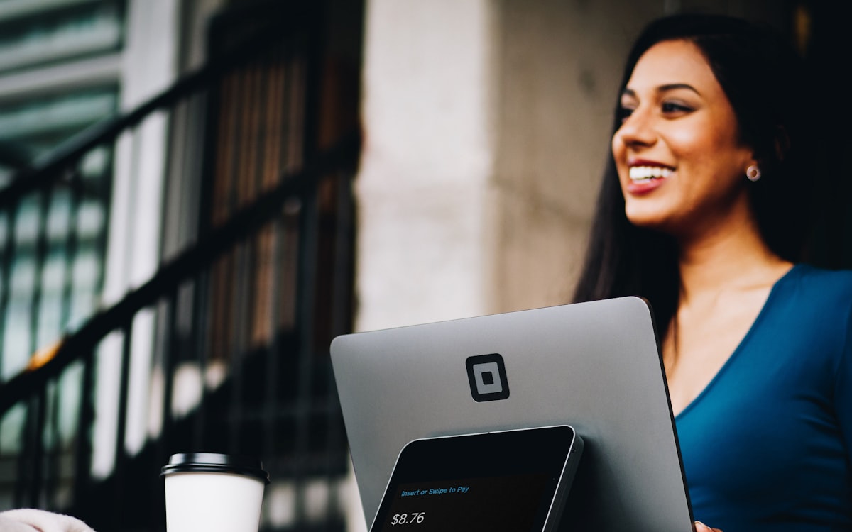 Profissional sorrindo ao usar o notebook com um CRM para WhatsApp organizando o atendimento