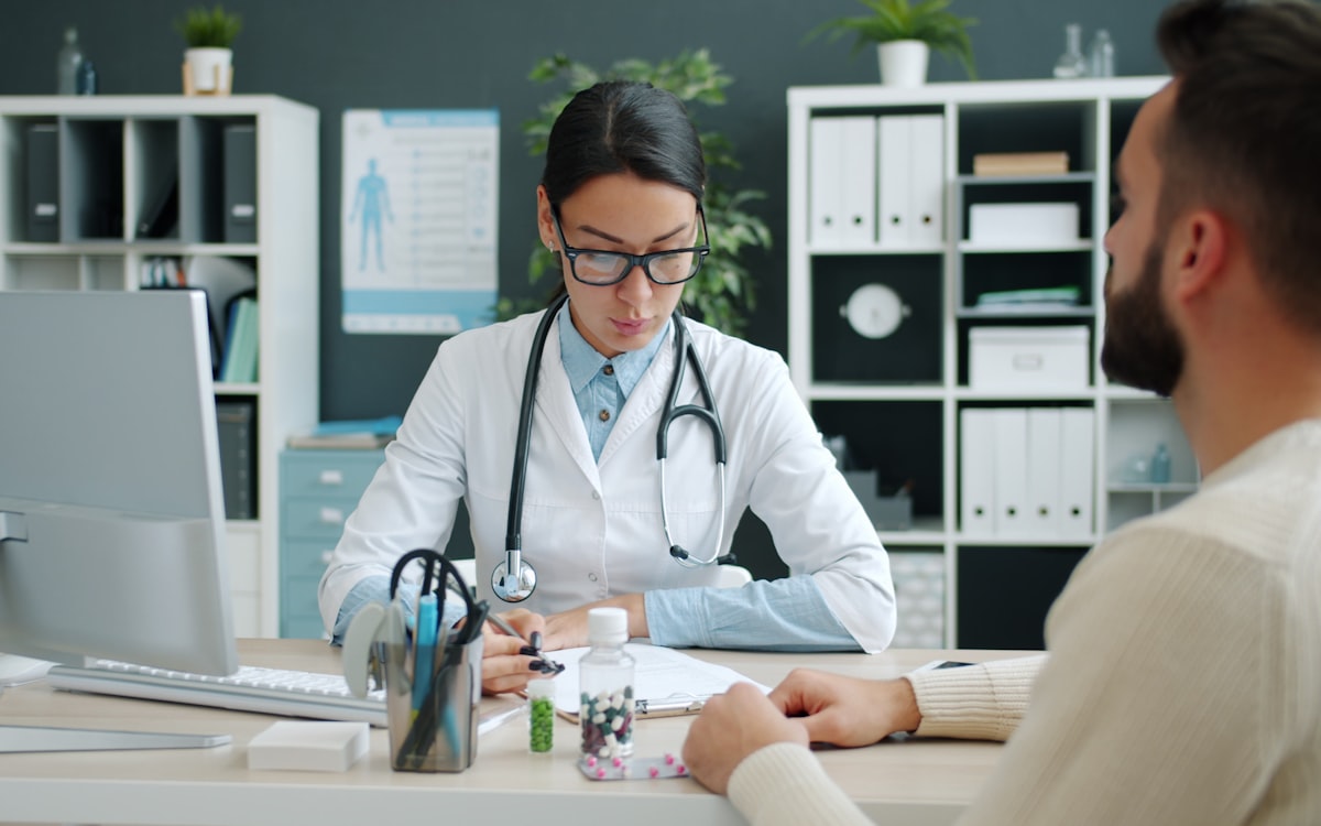 Médica atendendo paciente em consultório — reduzir faltas em consultas com lembrete no WhatsApp